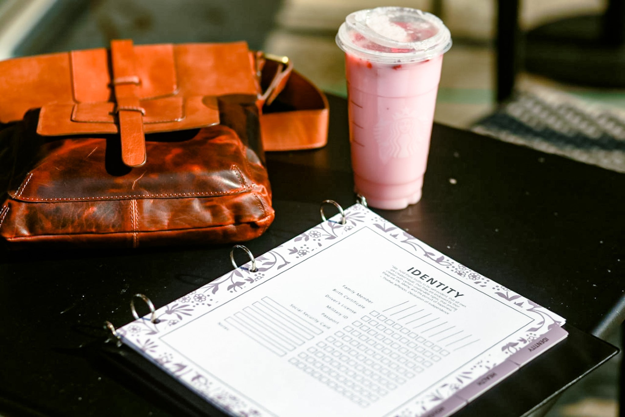 PCS binder set, drink, and bag on table